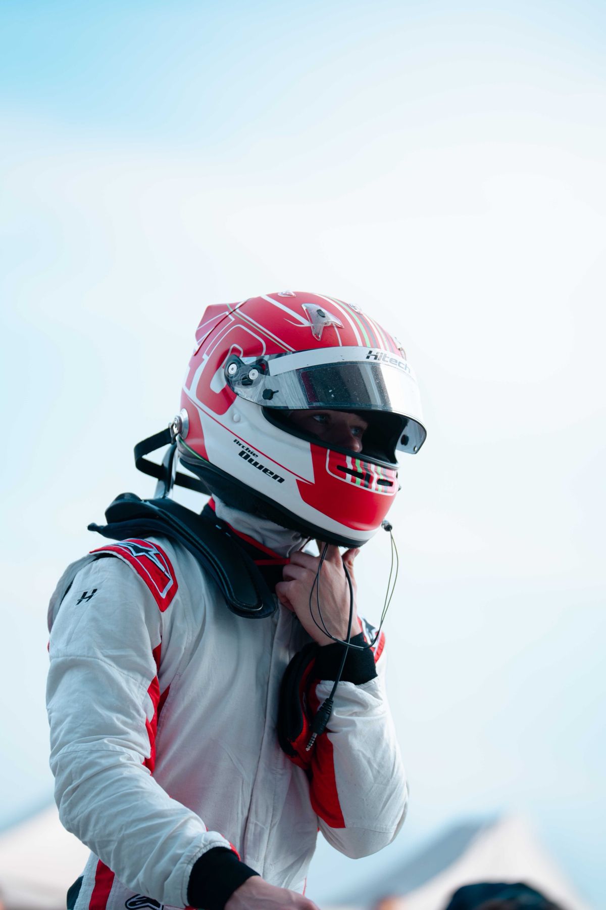 Archie Owen in his red and white helmet, fastening his strap